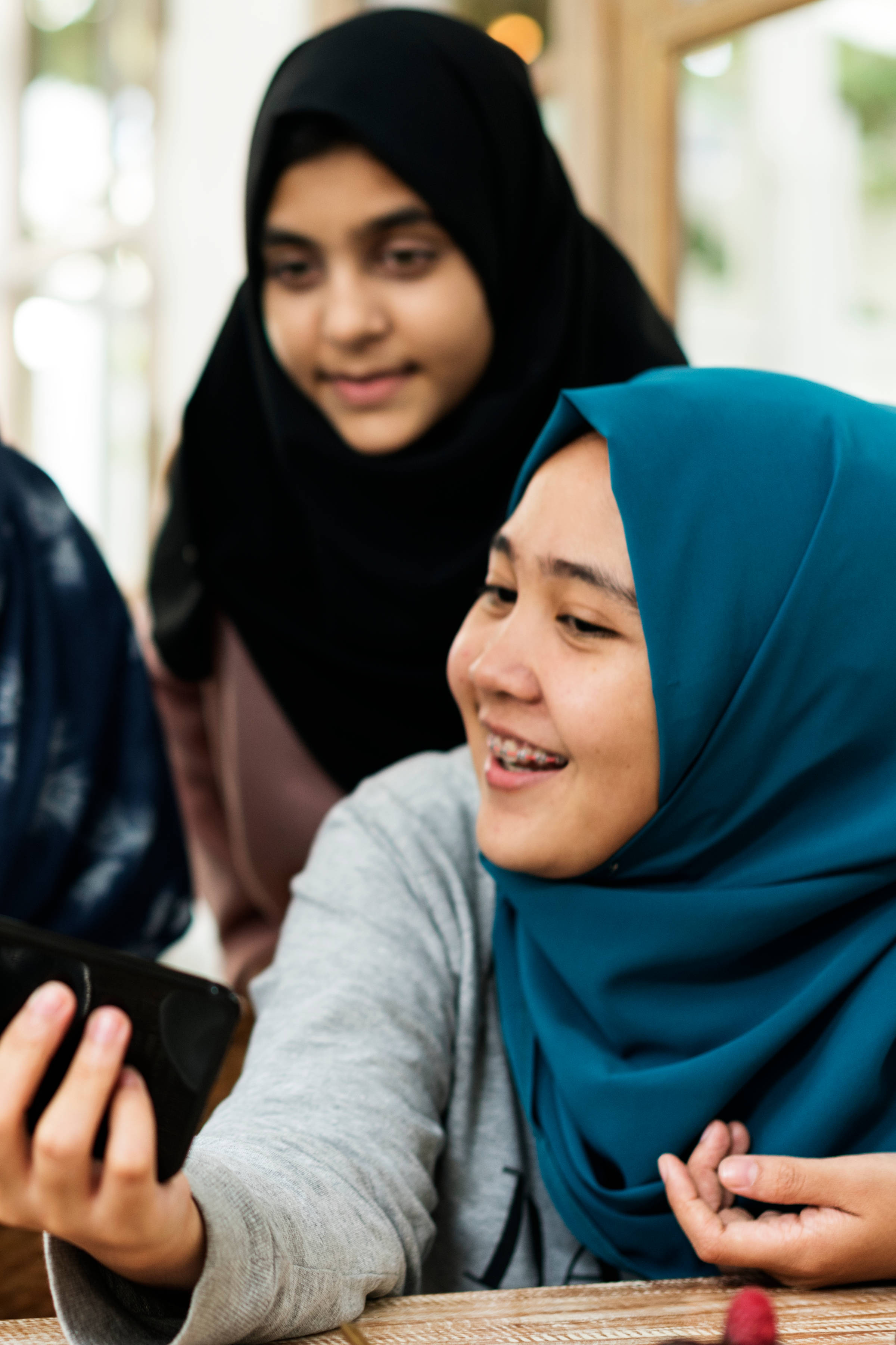 Women looking at a mobile phone. Photo: Rawpixel / iStock.